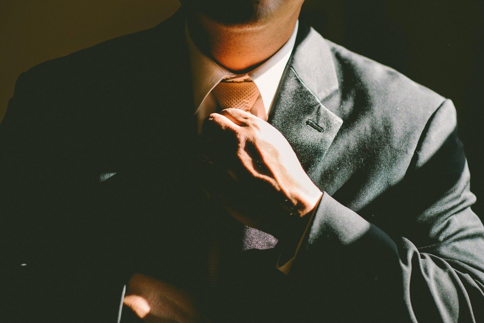 A close-up shot of a business man tightening his tie