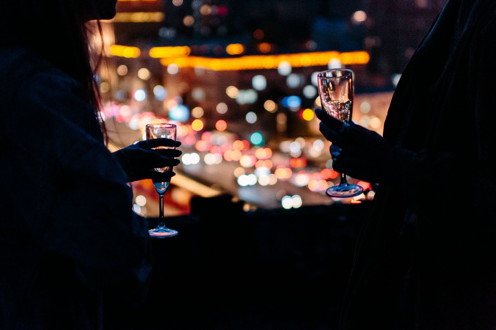 A silhouette of people enjoying a drink at a rooftop bar